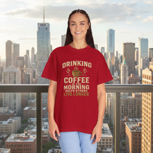 Person wearing a red t-shirt with a coffee-themed message