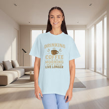 Woman wearing a light blue t-shirt with a coffee-themed message on a white background